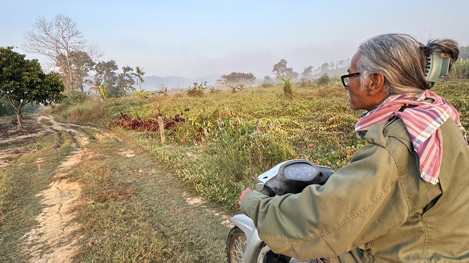 A local on a motorbike at first light, leaving Sai Yok